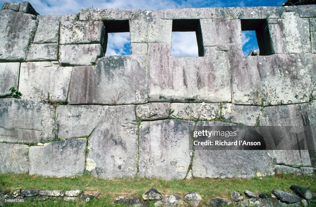 Stone wall with windows at the ancient Inca city of Machu Picchu.