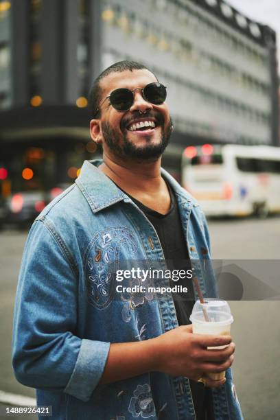 stylish young gay man drinking coffee and laughing in the city - alternative lifestyle stock pictures, royalty-free photos & images