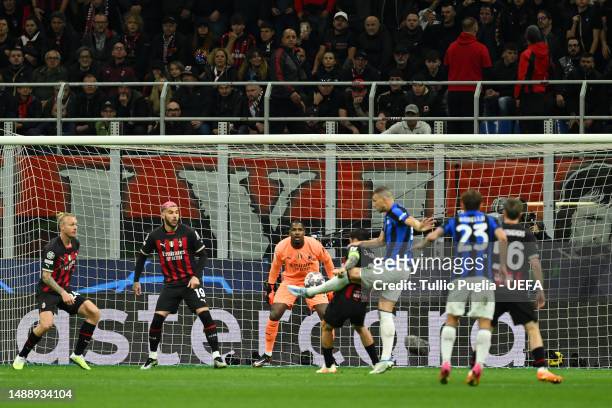 Edin Dzeko of FC Internazionale scores the team's first goal as Mike Maignan of AC Milan looks on during the UEFA Champions League semi-final first...