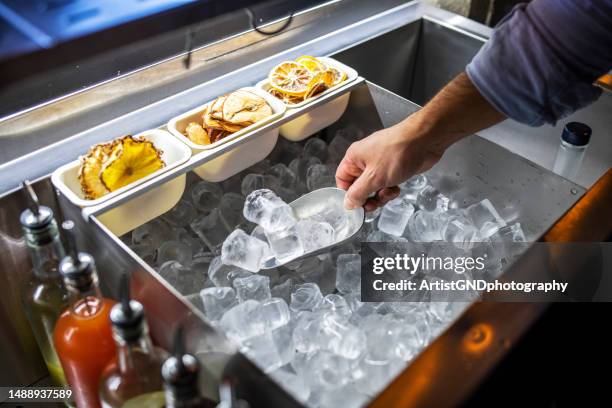 barman colocando cubos de gelo em um copo. - ice cube - fotografias e filmes do acervo