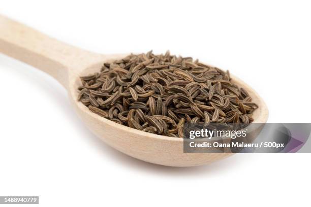 close-up of cumin seeds in spoon on white background,romania - cumin stock pictures, royalty-free photos & images