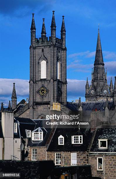 churches rise above buildings in the city centre. the building with the square tower now houses a pub called slain's castle. - aberdeen scotland city stock pictures, royalty-free photos & images