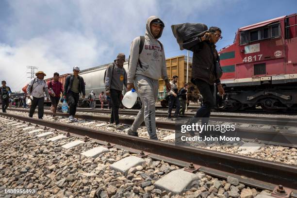 Immigrants walk after disembarking a freight train en route to the U.S.-Mexico border on May 10, 2023 near Ciudad Juarez, Mexico. Many migrants make...