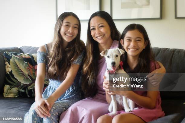 casual indoor portrait of a hawaiian family with mother, teen daughters and family pet dog - polynesische etniciteit stockfoto's en -beelden