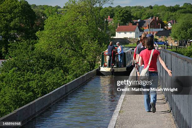 canal boat travelling along pontcysyllte aqueduct. - aqueduct stock-fotos und bilder