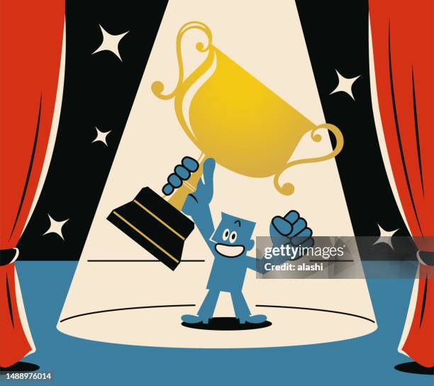 stockillustraties, clipart, cartoons en iconen met a smiling blue man holding the trophy aloft on stage with a spotlight - officiële openingen