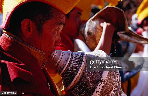 monk sounding conch shell at mani rimdu festival. - mani rimdu festival stock-fotos und bilder