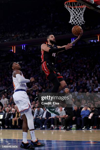 Caleb Martin of the Miami Heat shoots the ball over RJ Barrett of the New York Knicks during the first quarter in game five of the Eastern Conference...