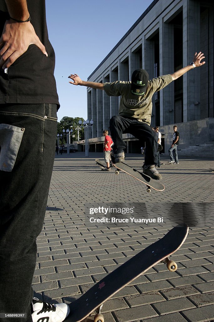 Young people practising their skateboard skills near east side of Palace of the Republic.