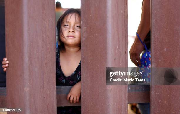 Ecuadoran immigrant Janina stands by her father and other immigrants seeking asylum in the U.S. Awaiting processing by Border Patrol agents after...