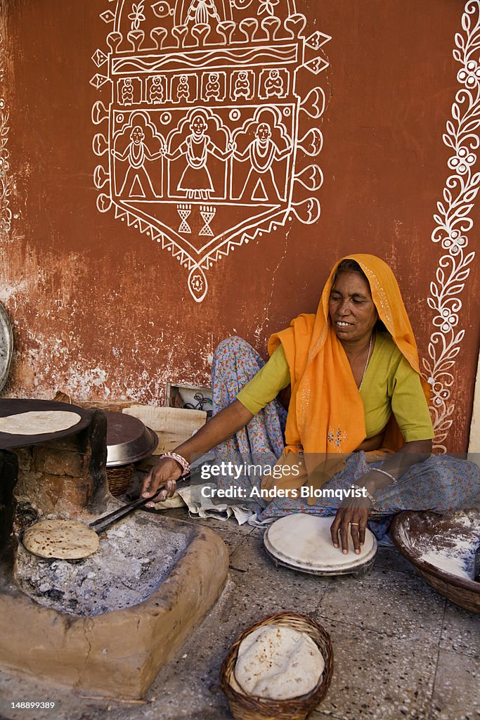 Woman making chapati bread on coals the traditional way.