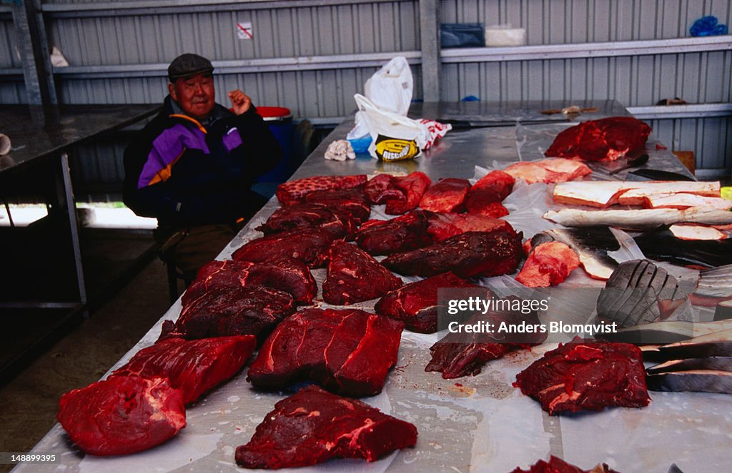 Man selling whale meat at Braedet (hunters and fishers market).