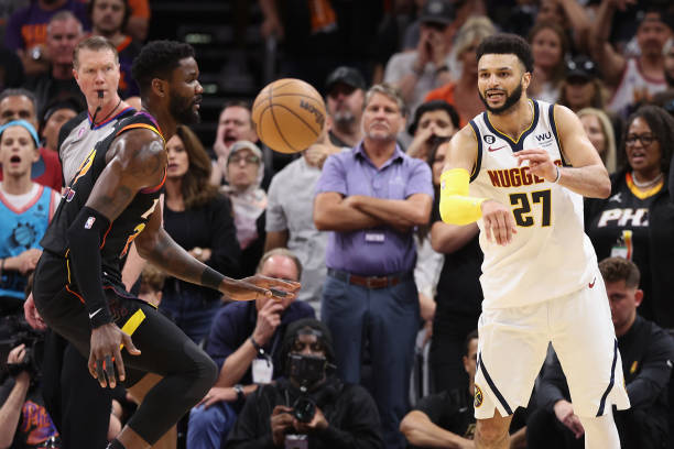 Jamal Murray of the Denver Nuggets passes the ball around Deandre Ayton of the Phoenix Suns during Game Four of the NBA Western Conference Semifinals...