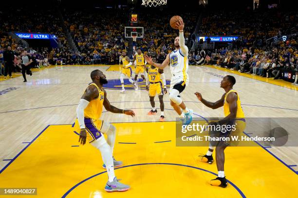 Stephen Curry of the Golden State Warriors drives to the basket against LeBron James and Lonnie Walker IV of the Los Angeles Lakers during the second...