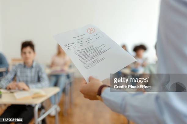 teacher with test results - exam paper stock pictures, royalty-free photos & images