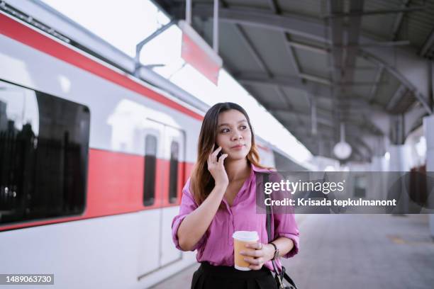 asian businesswoman making phone call while traveling to client's office via rapid transit. - commuter benefits stock pictures, royalty-free photos & images