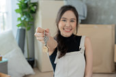 Moving house, relocation. Woman hold key house keychain in new house. move in new home. Buy or rent real estate. flat tenancy, leasehold property, new landlord, dwelling, loan, mortgage.