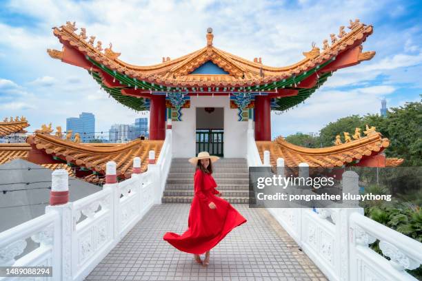 a woman flaunts a red skirt smiling happily at thean hou chinese temple in kuala lumpur. malaysia. - woman red lantern stock pictures, royalty-free photos & images