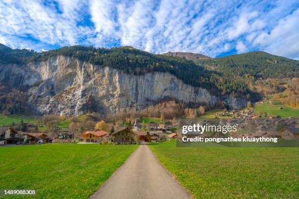 the front view has access roads and mountains against the sky and forests, cloudy skies, and the trees at the foothills are changing colors from autumn. of the city of lauterbrunnen switzerland. - lauterbrunnen photos et images de collection