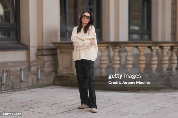 Elise Seitz seen wearing Birkenstock beige olive shoes, Toteme black pants, Soho Studios white knit sweater, Chanel black leather handbag, Bottega...