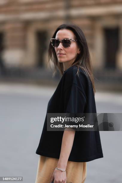 Elise Seitz seen wearing a Bottega Veneta Jodie black leather bag, Isabel Marant black boots, Soho Studios black shirt and beige and brown pants and...