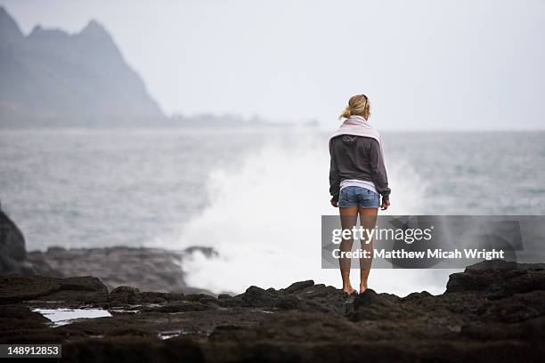 woman on rock ledge at queens bath salt water pools. - princeville stock pictures, royalty-free photos & images