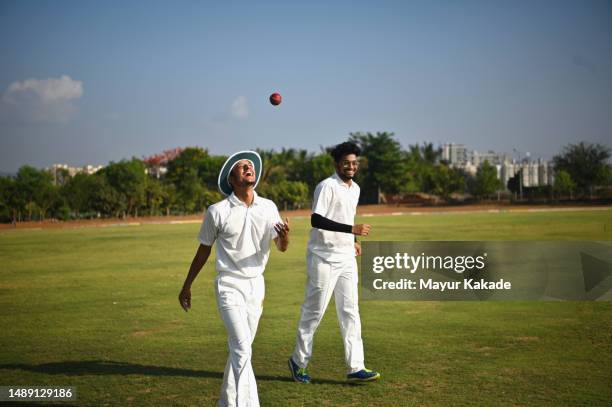 cricket fielder celebrating after catching the ball while fielding in the cricket ground - cricket ball catch stock pictures, royalty-free photos & images