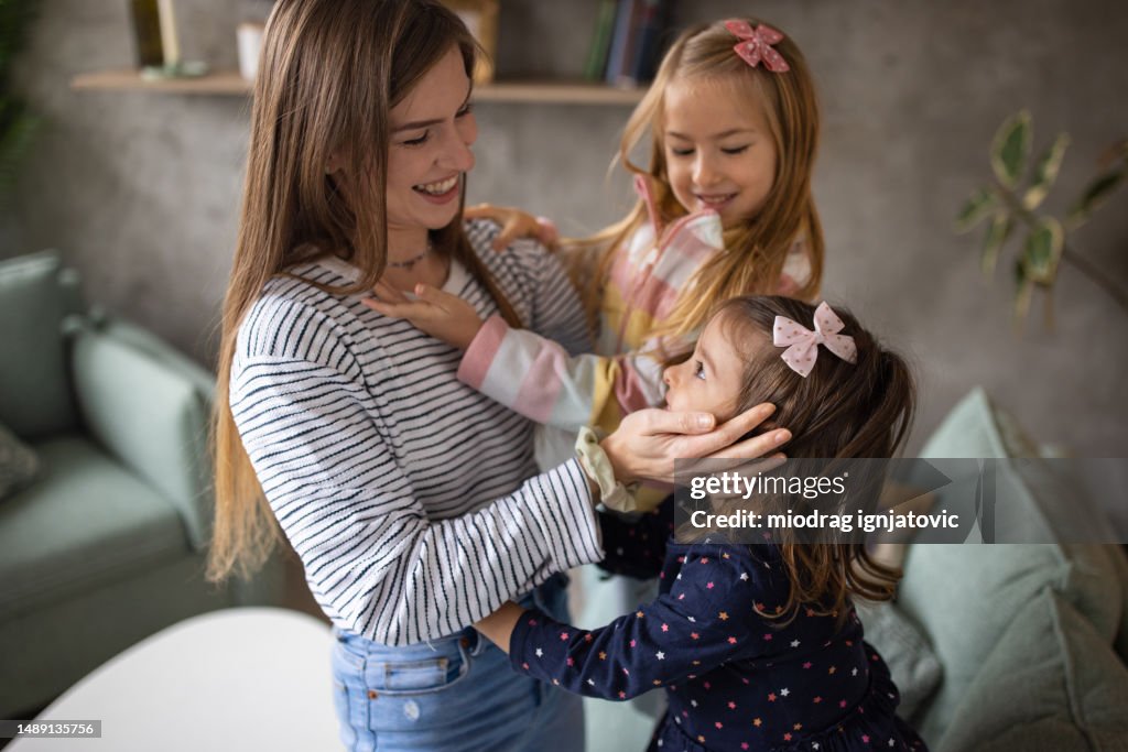 Mother playing with her daughters at home