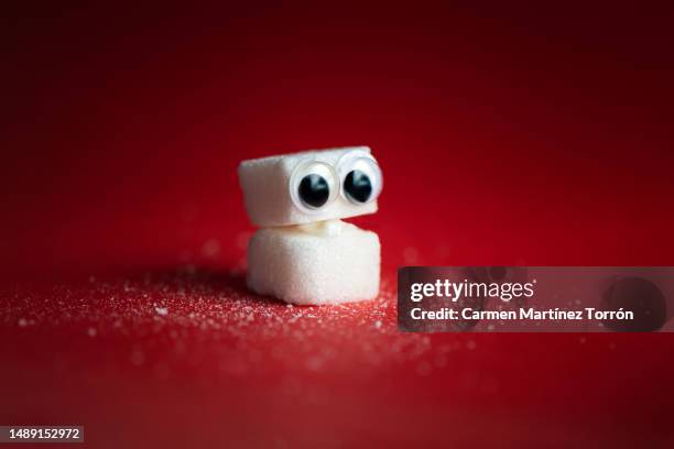 sugar cubes on red background. - fruchtzucker stock-fotos und bilder