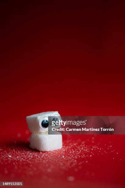 sugar cubes on red background. - fructose stock pictures, royalty-free photos & images