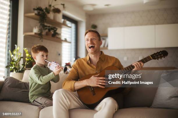 little boy and his father playing on musical instruments. - trumpet stock pictures, royalty-free photos & images