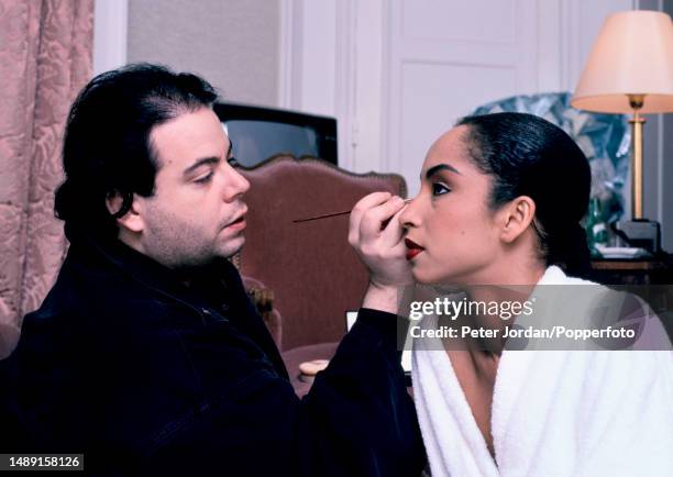 Nigerian born British singer Sade Adu has her make-up applied by a make-up artist prior to a stage performance during a tour of West Germany in March...