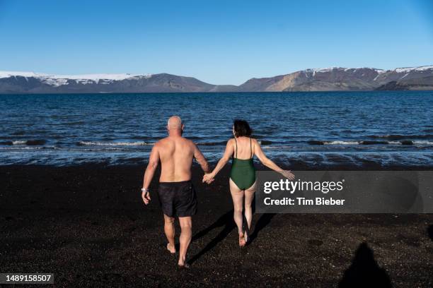 couple walking in the water in antarctica. - nieuwjaarsduik stockfoto's en -beelden