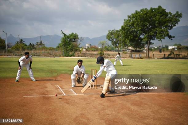 batsman hitting a cover drive shot during a cricket match - cricket jersey stock pictures, royalty-free photos & images