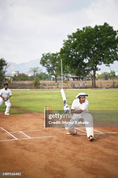 batsman playing a sweep shot during a cricket match - cricket team stock pictures, royalty-free photos & images