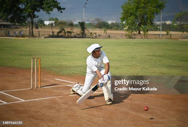 batsman playing a sweep shot during a cricket match - indian cricket player stock pictures, royalty-free photos & images