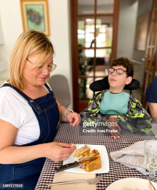 mamá alimentando a su hijo con parálisis cerebral - choking food fotografías e imágenes de stock