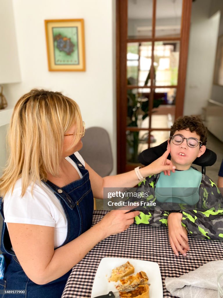 Mom feeding her son with cerebral palsy
