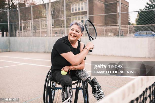 disabled latin woman practice wheelchair tennis outdoors - wheelchair tennis stockfoto's en -beelden