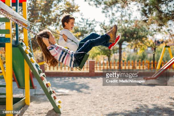 happy children swinging in the park - boy girl stock pictures, royalty-free photos & images