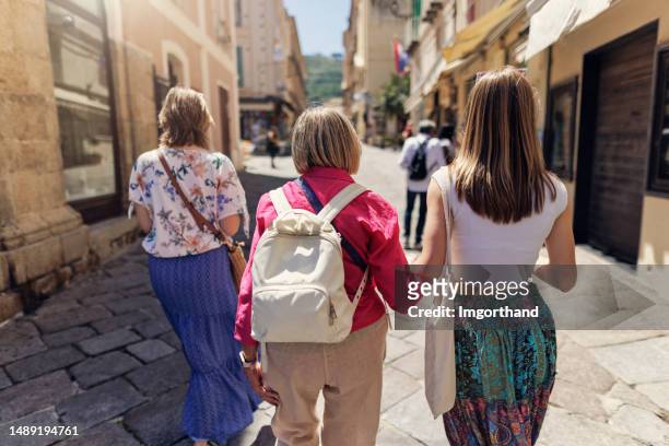 portrait of a teenage girl with mother and grandmother enjoying time together in the town streets - fashionable grandma stock pictures, royalty-free photos & images