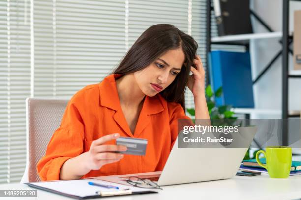 problemas financieros, compras en línea sin éxito. mujer sorprendida con computadora portátil y tarjeta de crédito - corrupción corporativa fotografías e imágenes de stock