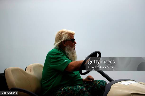 John Daly of the United States drives a golf cart between the third and fourth holes during the first round of the Regions Tradition at Greystone...