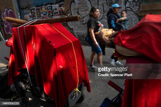 People walk by religious icons along Roosevelt Avenue, which passes through the neighborhoods of Elmhurst, Corona and Jackson Heights, areas that...