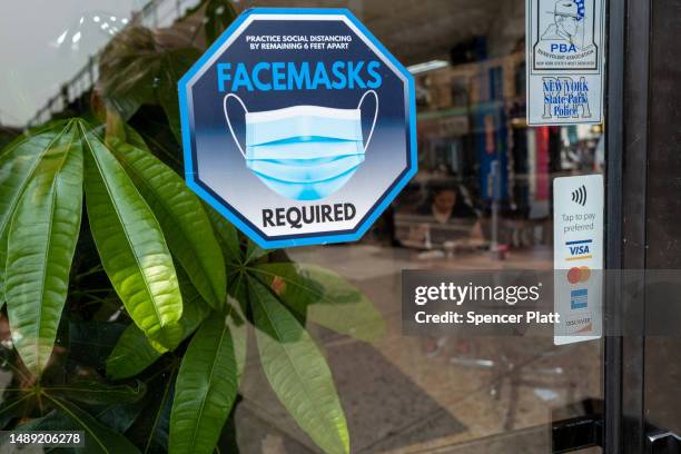 Face mask sign is displayed in a window along Roosevelt Avenue, which passes through the neighborhoods of Elmhurst, Corona and Jackson Heights, areas...