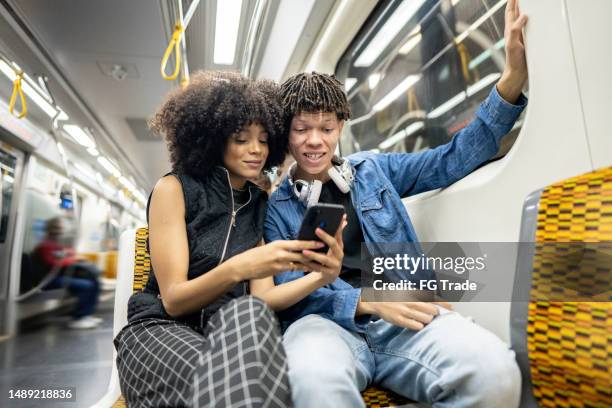 friends using the mobile phone on the subway train - são paulo stock pictures, royalty-free photos & images