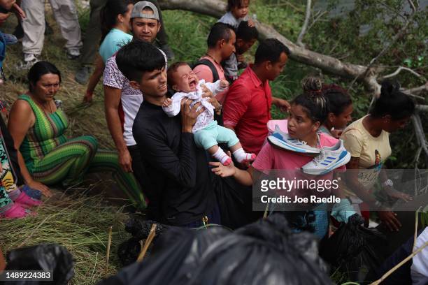 Migrants make their way into the Rio Grande as they cross to enter the United States on May 11, 2023 in Matamoros, Mexico. A surge of migrants is...