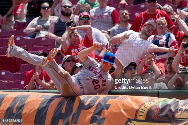 Pete Alonso of the New York Mets falls over a tarp attempting to catch a foul ball in the eighth inning against the Cincinnati Reds at Great American...