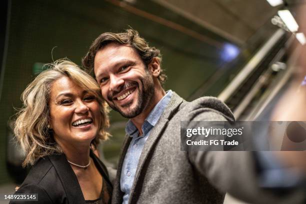 coworkers taking selfies at a subway station - camera point of view - business mature couple portrait stock pictures, royalty-free photos & images