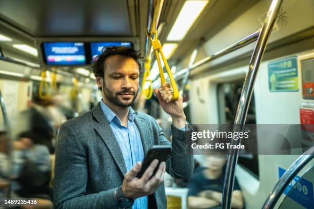 mature man using the mobile phone in a train - underground rail stock pictures, royalty-free photos & images